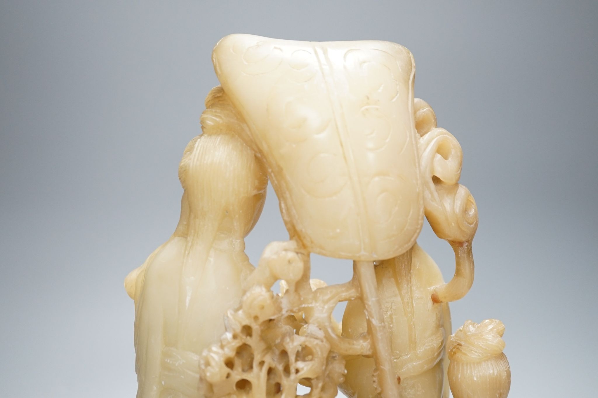 A Chinese soapstone carving of two ladies, wood stand, early 20th century, 36 cms high.